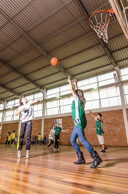 Gigante' do basquete atrai a atenção de crianças de escola em