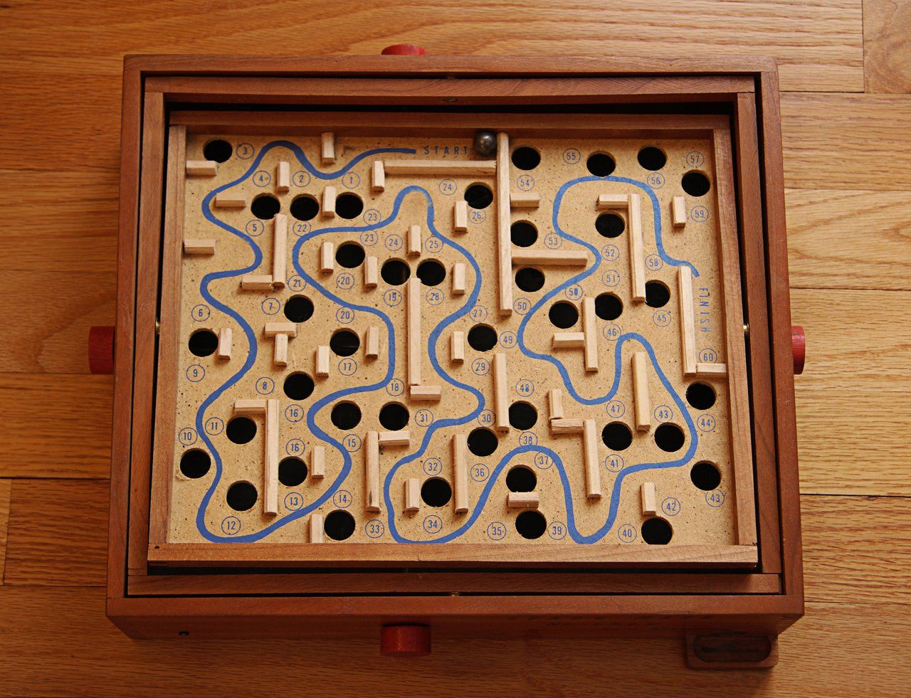 Imagem de um jogo de labirinto de madeira em uma mesa 