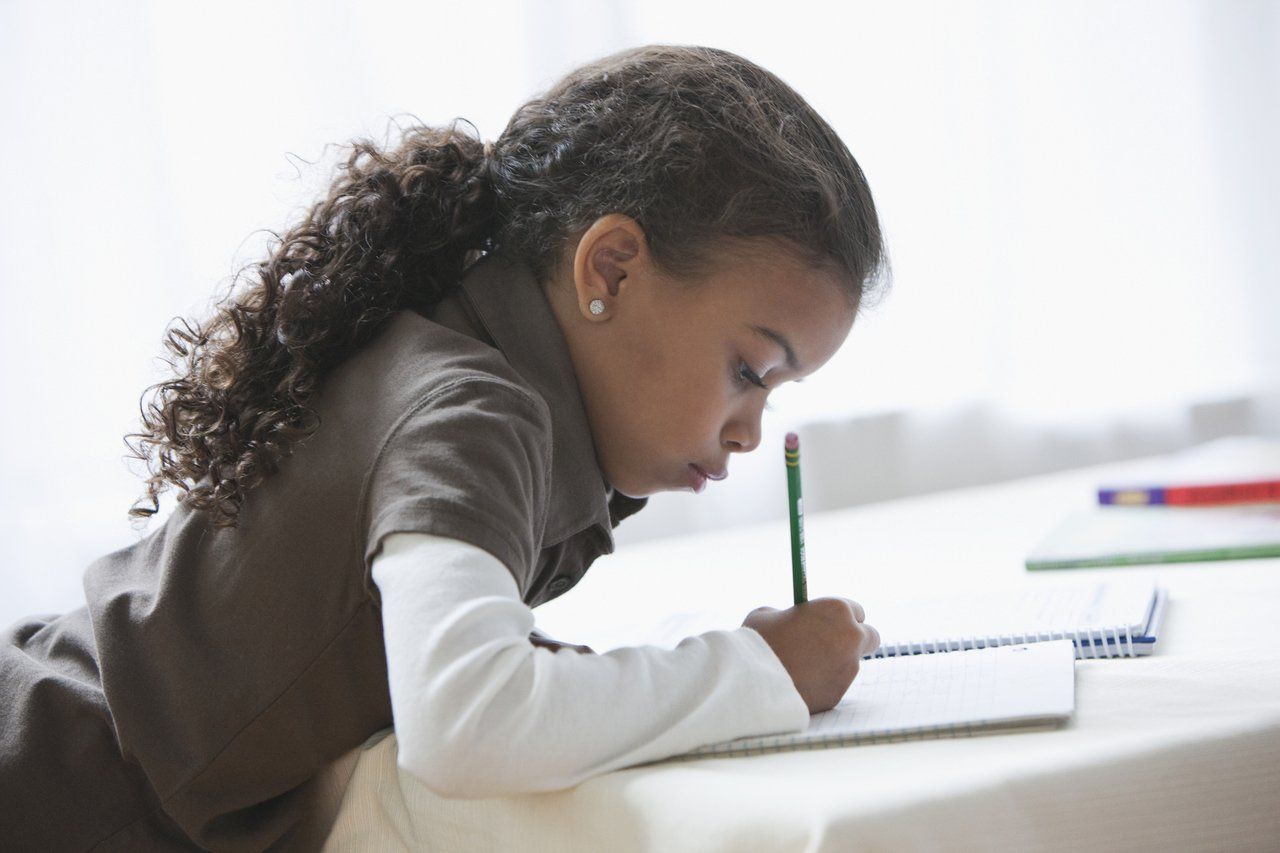 garota com lápis na mão escrevendo em uma folha