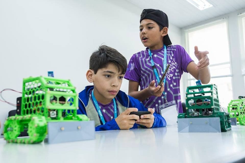 Dois alunos da Escola Municipal Aloys João Mann trabalham com os robôs que construíram