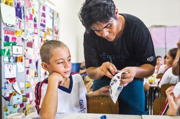 Imagens do teatro e dos alunos confeccionando os desenhos no