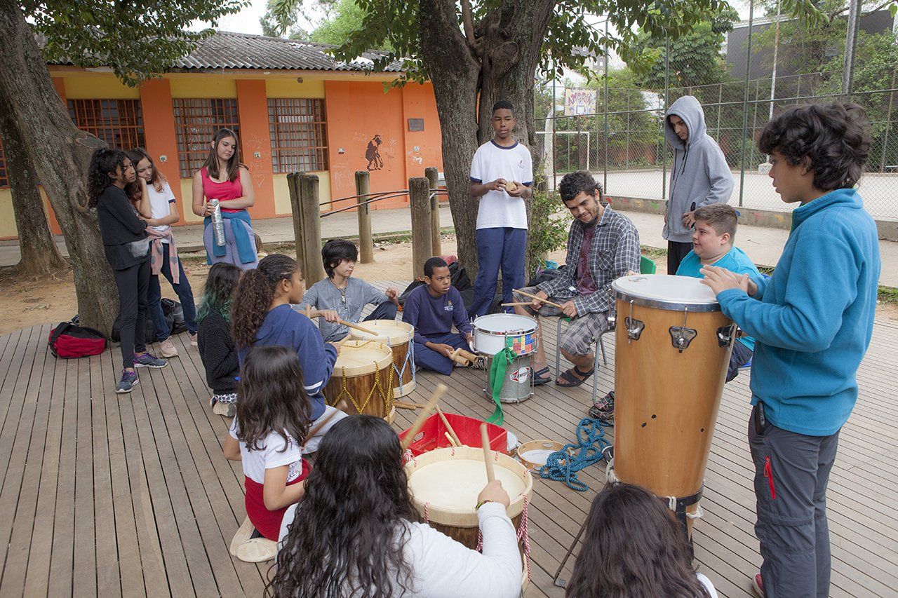 Alunos da escola municipal Desembargador Amorim Lima tocam instrumentos na área externa com muros coloridos