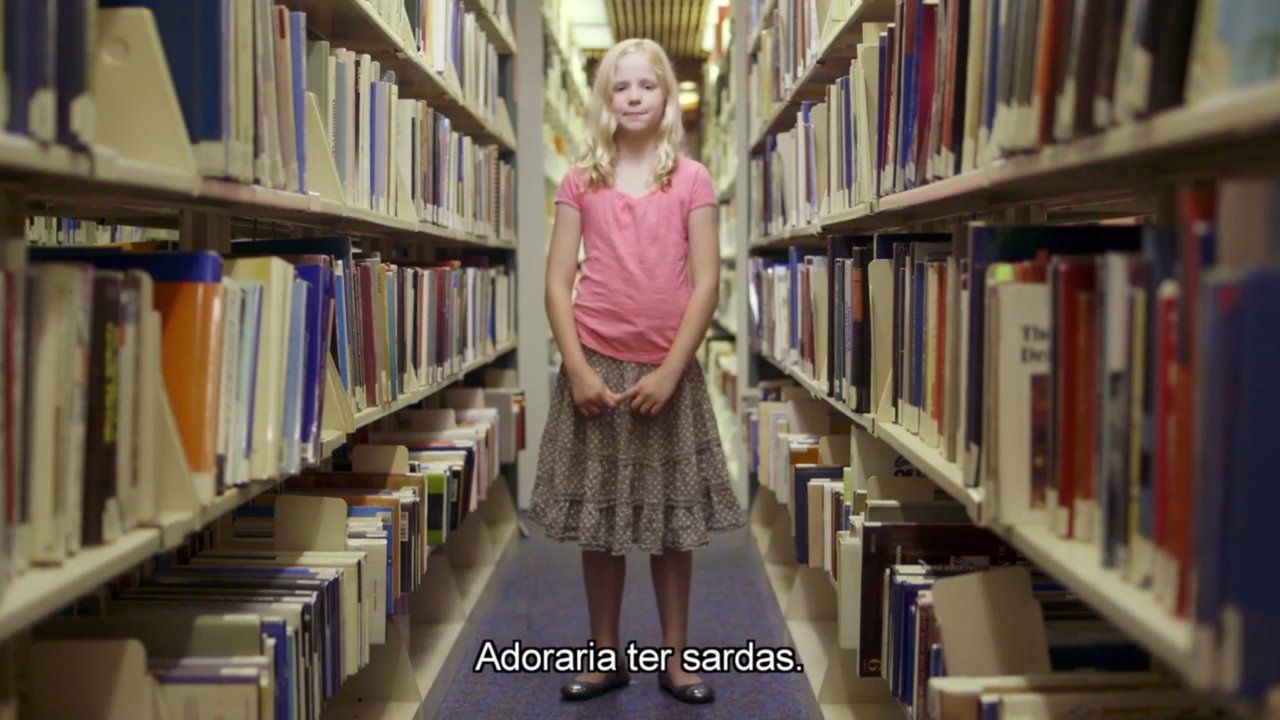 Foto de menina loira no meio de uma biblioteca com a frase "Adoraria ter sardas"
