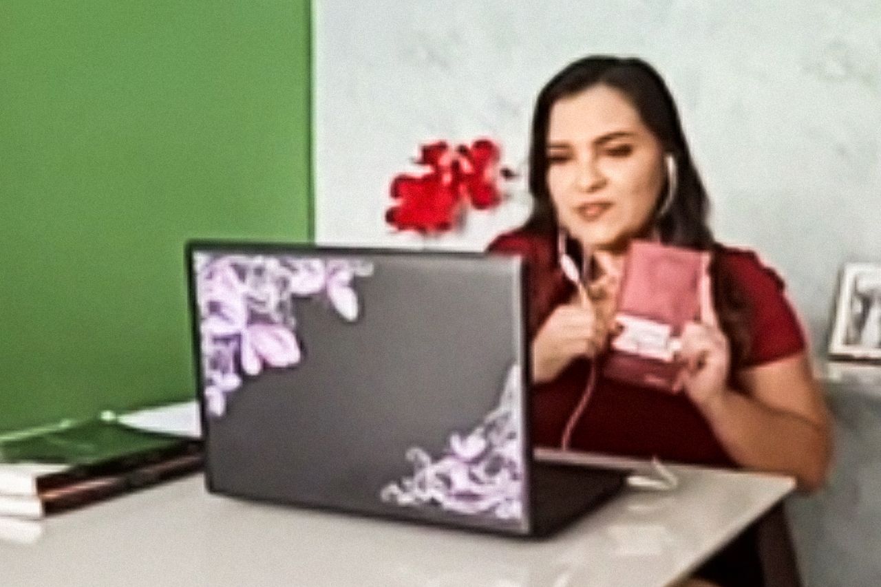 Fotografia produzida por vídeo chamada com a professora Marcia. A personagem utiliza o computador para fazer contato com os alunos além do planejamento de suas aulas..